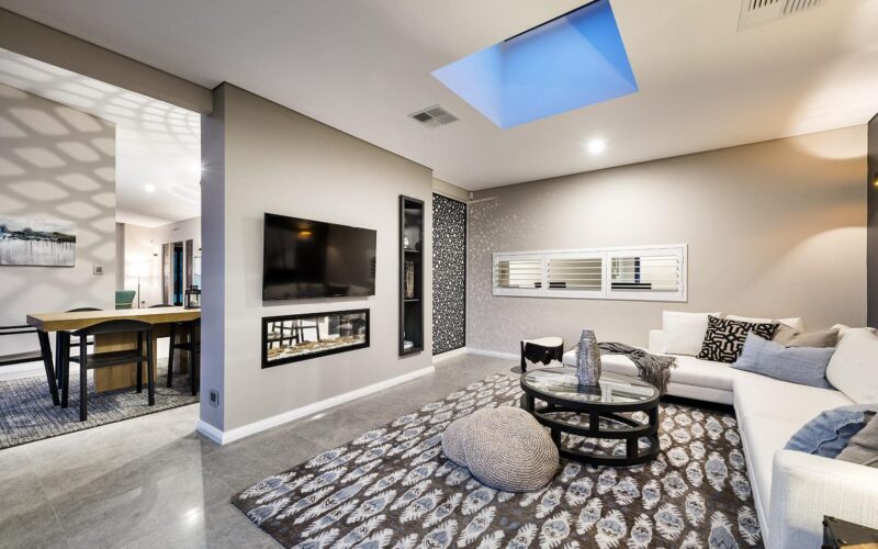 bright open plan living/dining with white walls and a skylight
