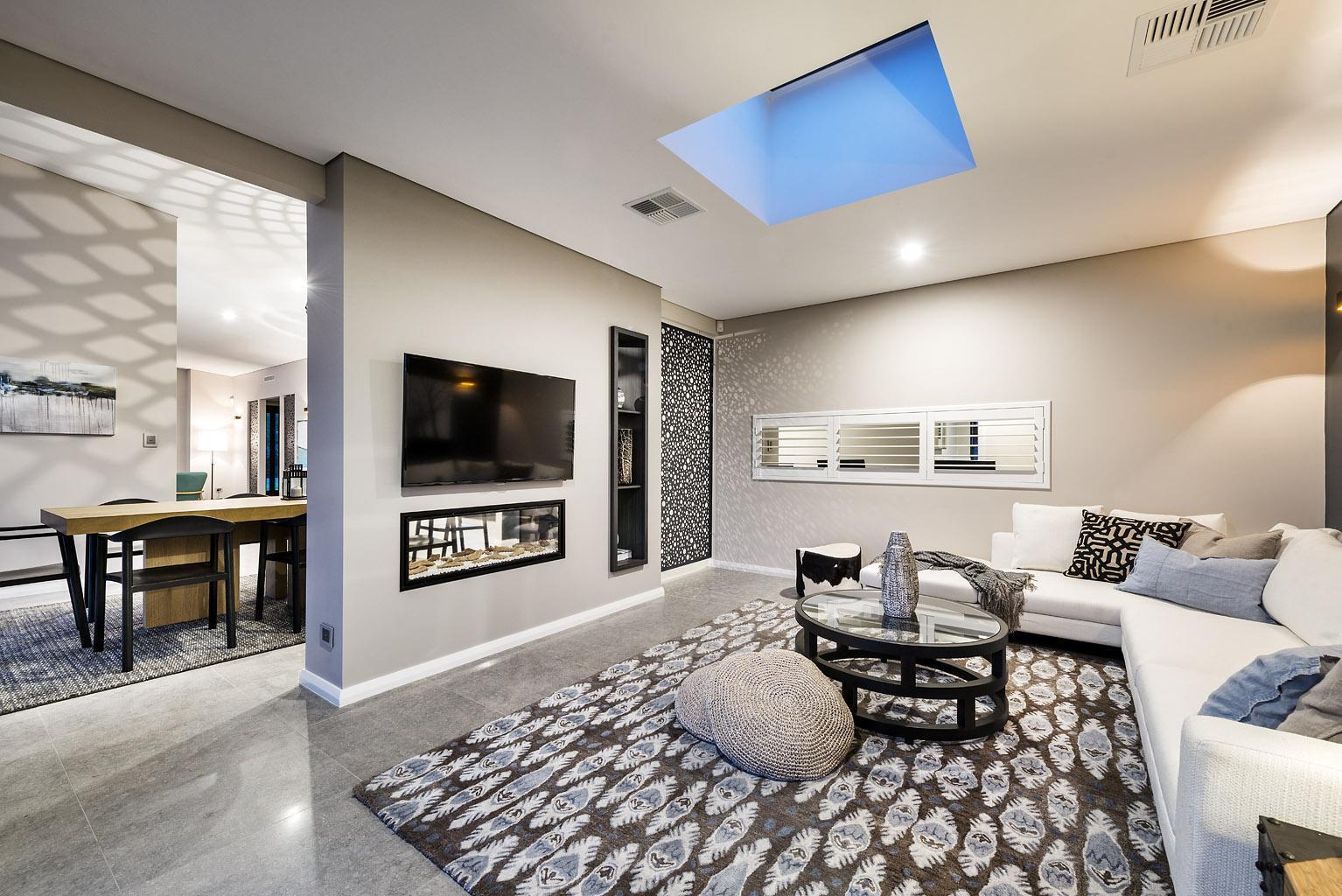 bright open plan living/dining with white walls and a skylight