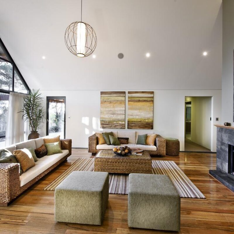 Living area with raked ceiling, full height glazing and stone fireplace