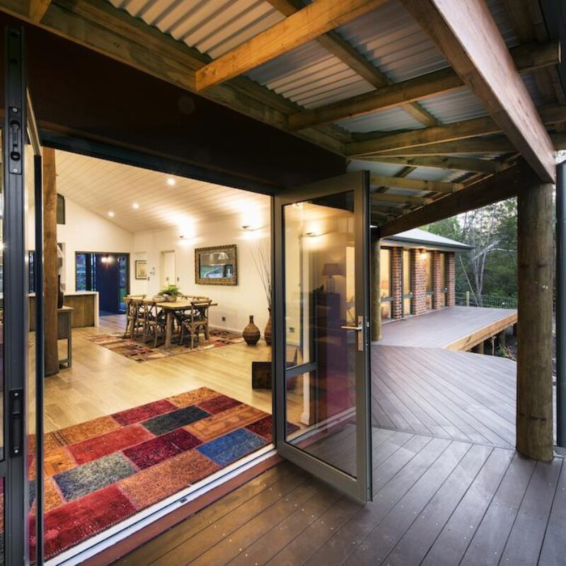 Bifold doors opening from the living area onto a timber decked verandah