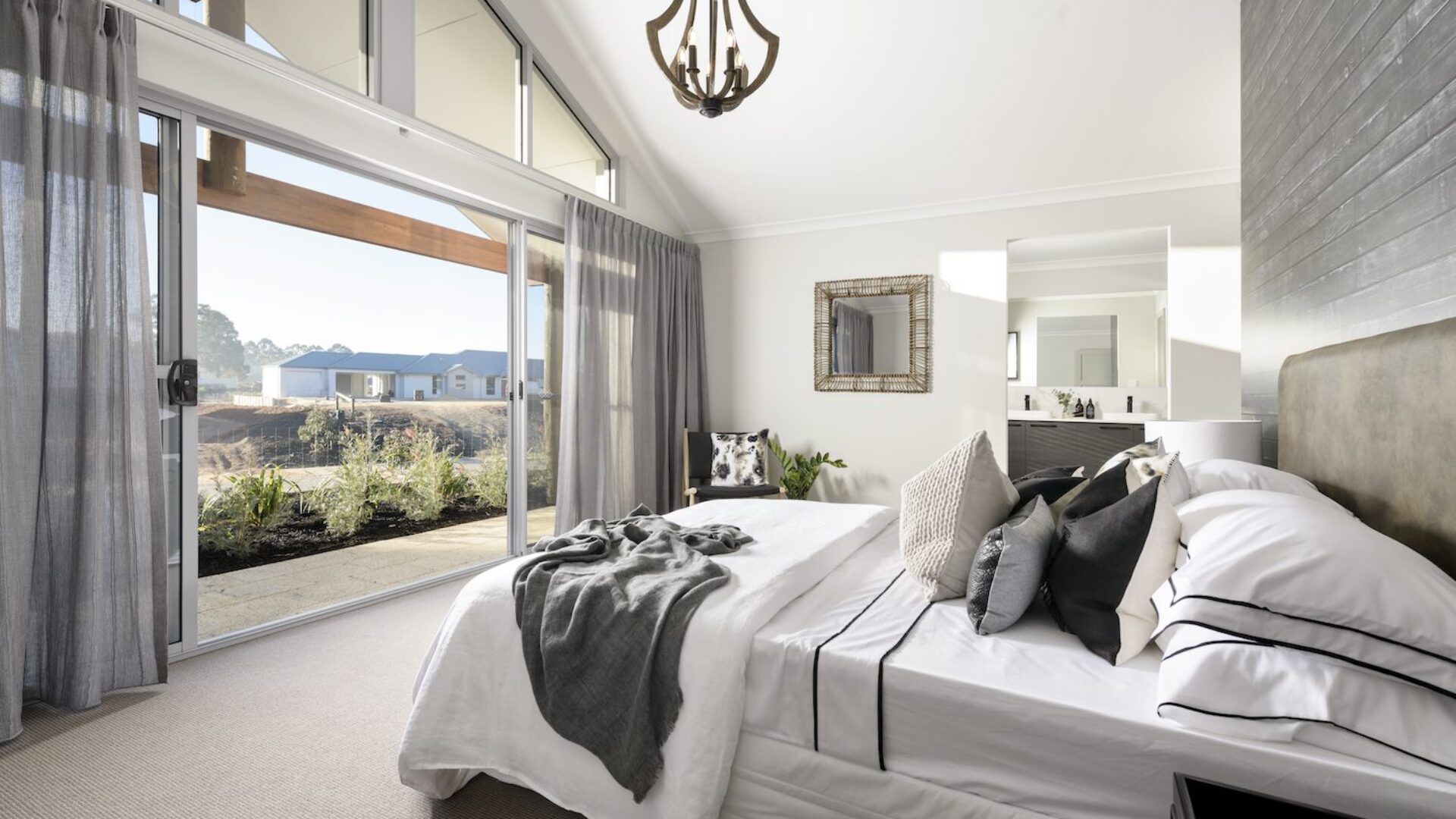 Bedroom with raked ceiling, chandelier and ensuite beyond