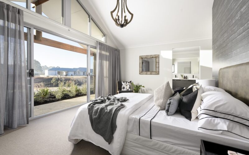 Bedroom with raked ceiling, chandelier and ensuite beyond