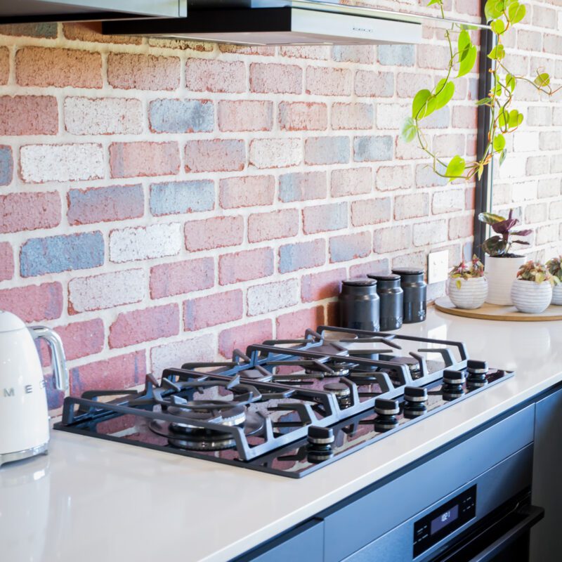 the marbelup gas cooker top and brick splash back