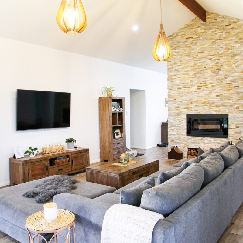 living area with wall mounted tV and open brick fireplace
