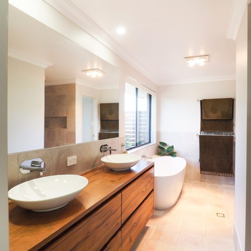 His and hers bathroom sinks on top of wooden vanity