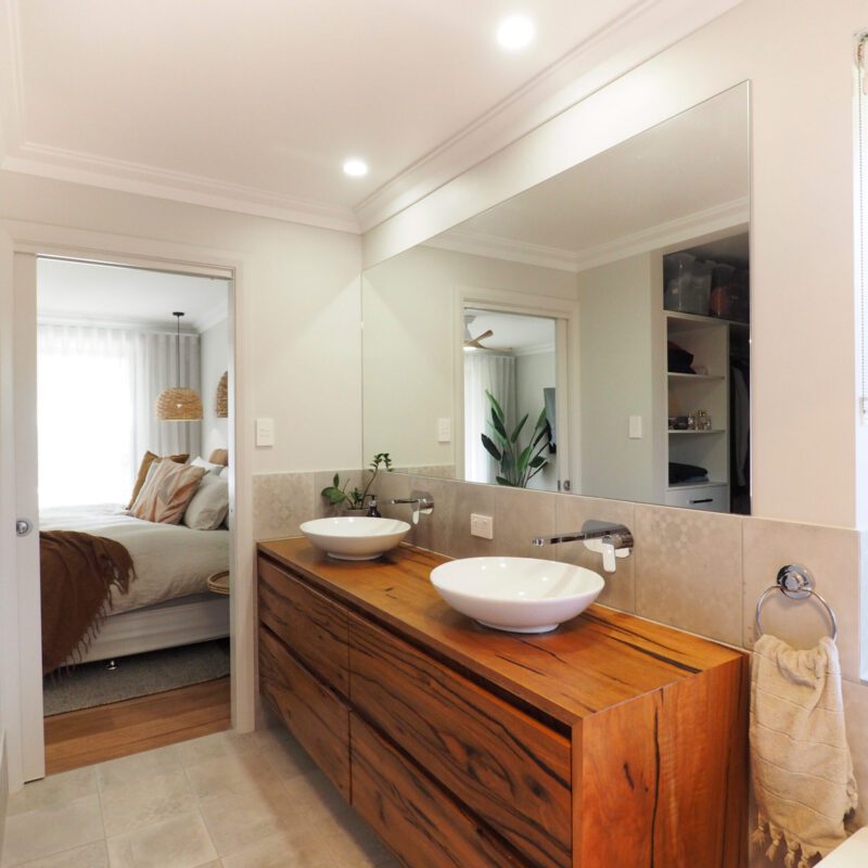 His and hers bathroom sinks on top of wooden vanity
