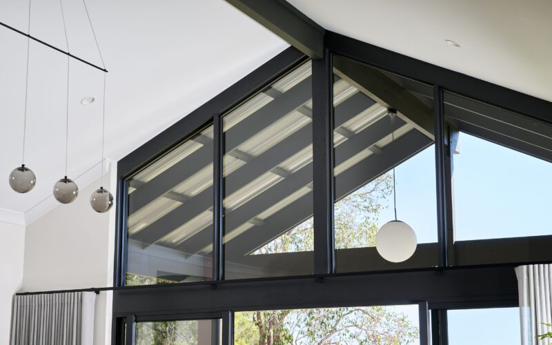 Gable glazing detail with black frames and pendant lights