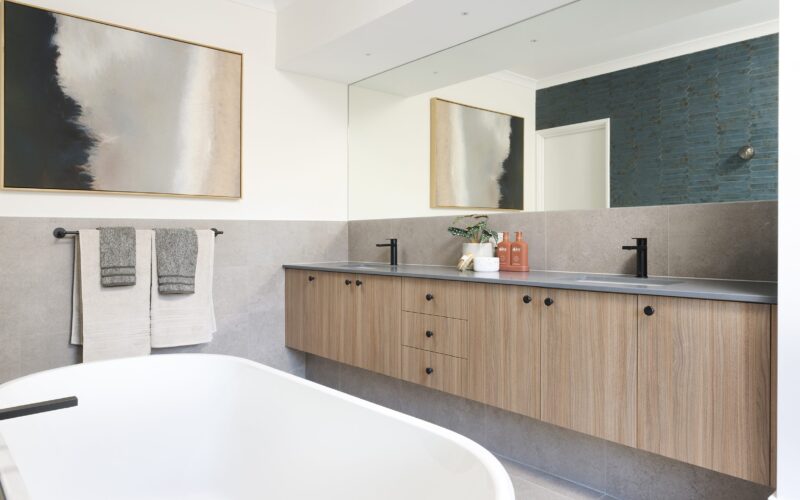 Bathroom with timber vanity, freestanding bath and framed artwork