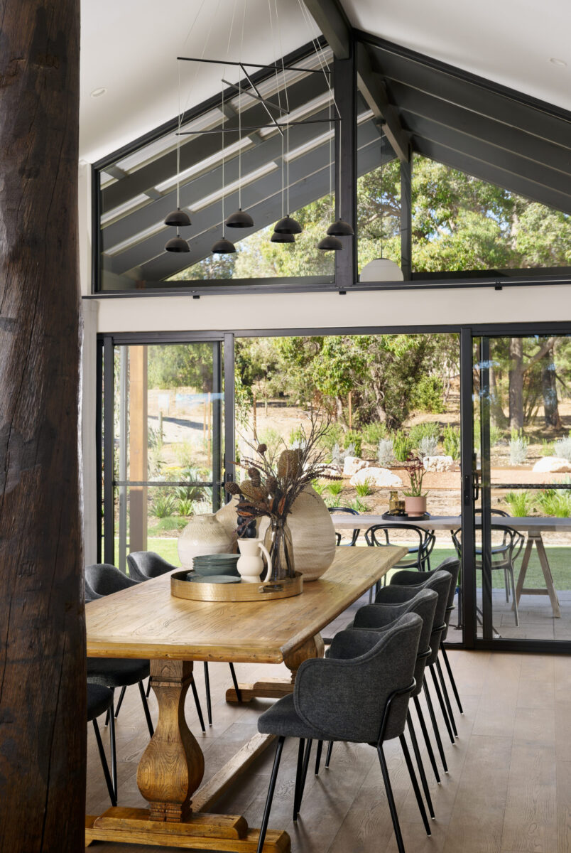 Dining area with round timber table and bifold doors to the verandah