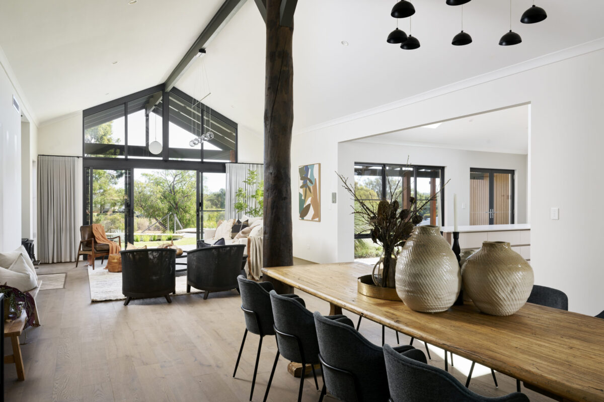 Open plan living and dining with raked ceiling and exposed timber pole