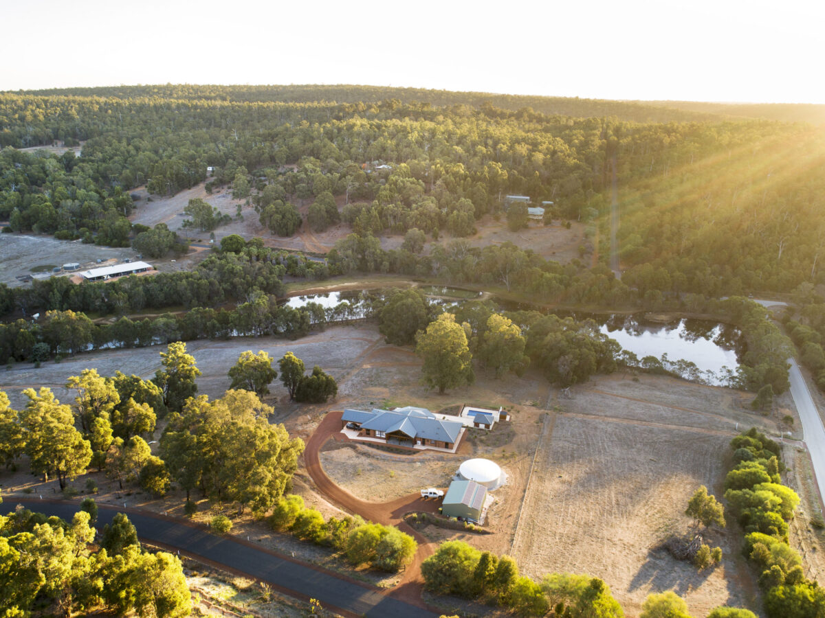 Aerial view of a rural property with bushland, dam and cleared paddocks