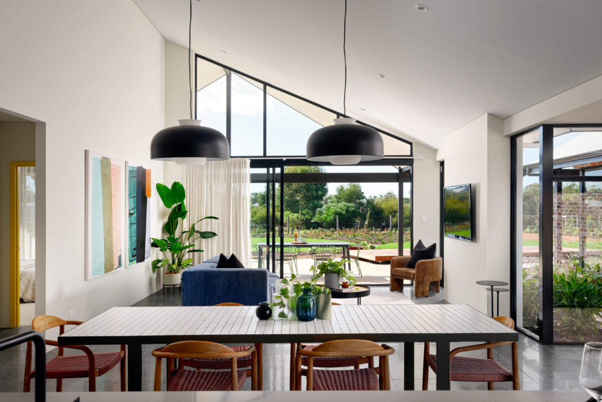 Dining area with black pendant lights and glazing out to the garden