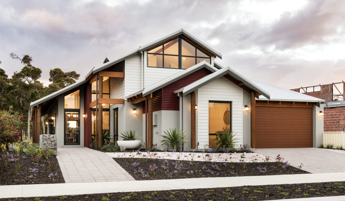 Two storey weatherboard home with gable glazing and landscaped garden beds
