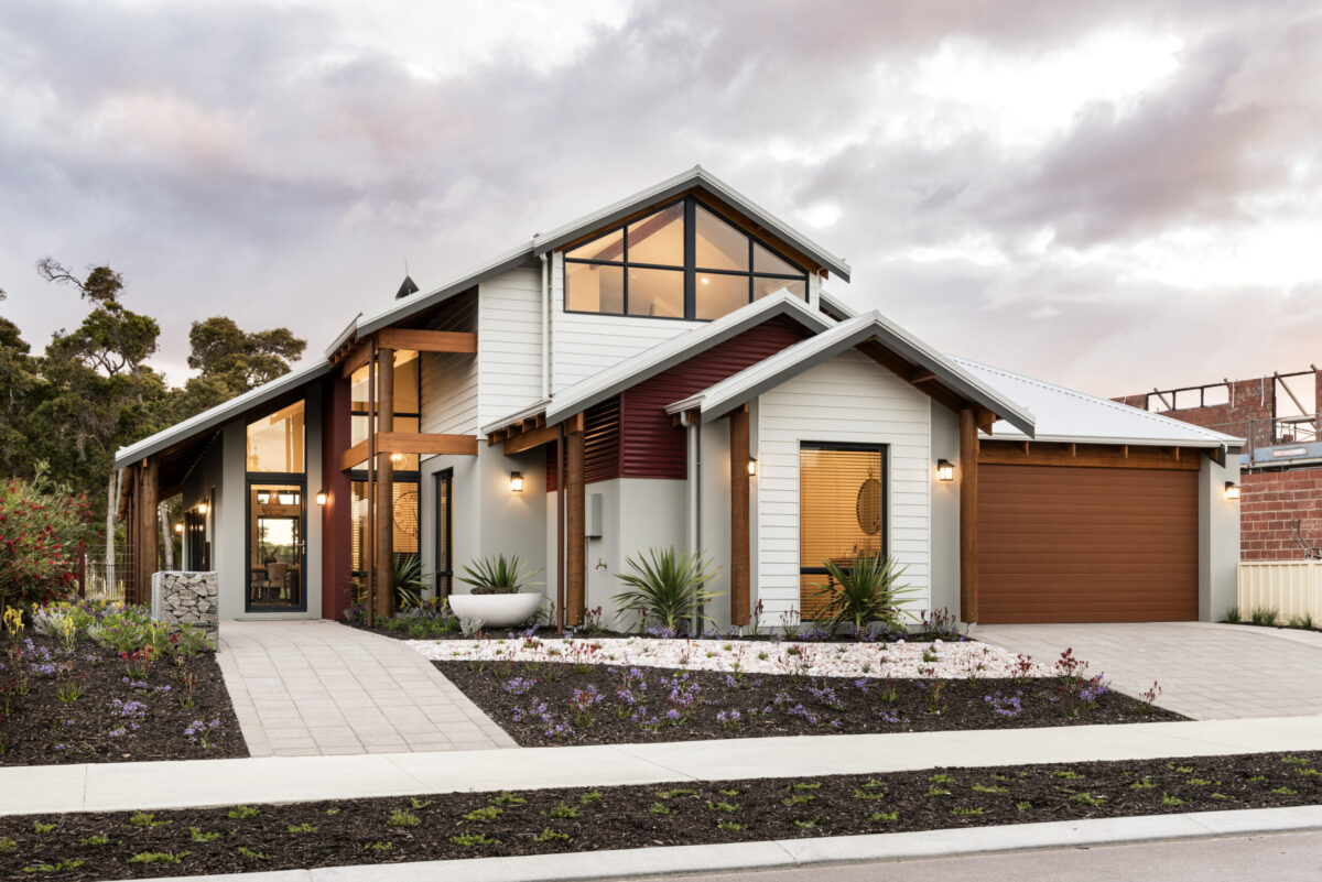 Two storey weatherboard home with gable glazing and landscaped garden beds