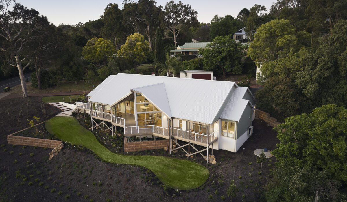 Aerial view of The Darlington display home with gable rooflines and landscaped grounds