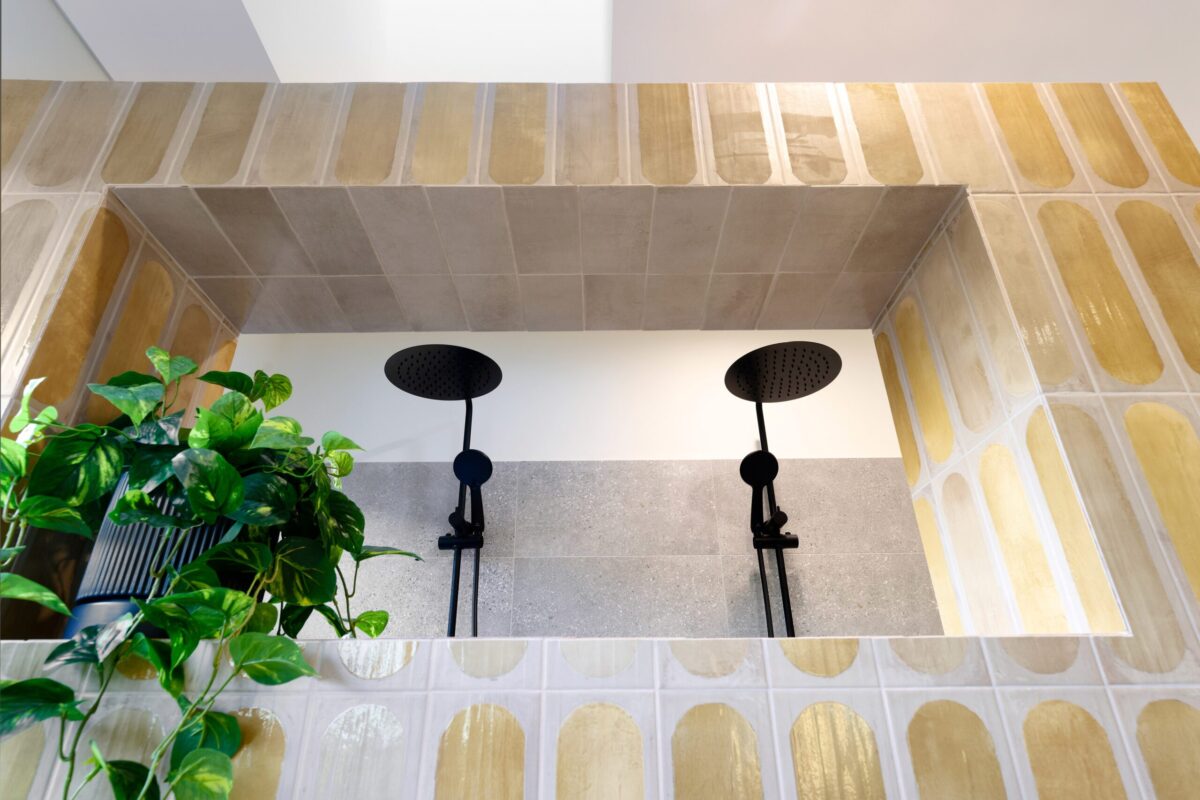 Shower with terracotta wall tiles, twin rain heads and indoor plants