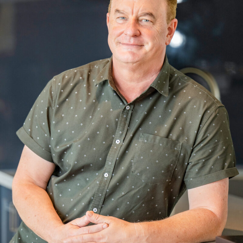 Portrait of a Country Builders team member leaning on a kitchen bench