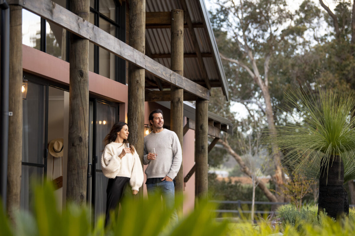 Clients standing on the verandah of their completed home with coffee