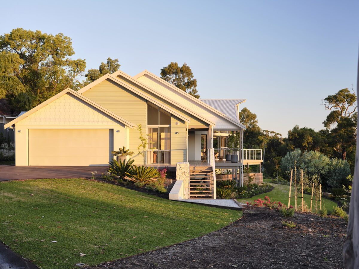 Weatherboard home with gable glazing, double garage and native garden beds