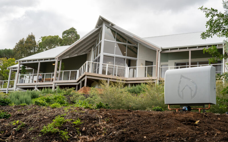 Home with gable glazing and wraparound verandah during landscaping works