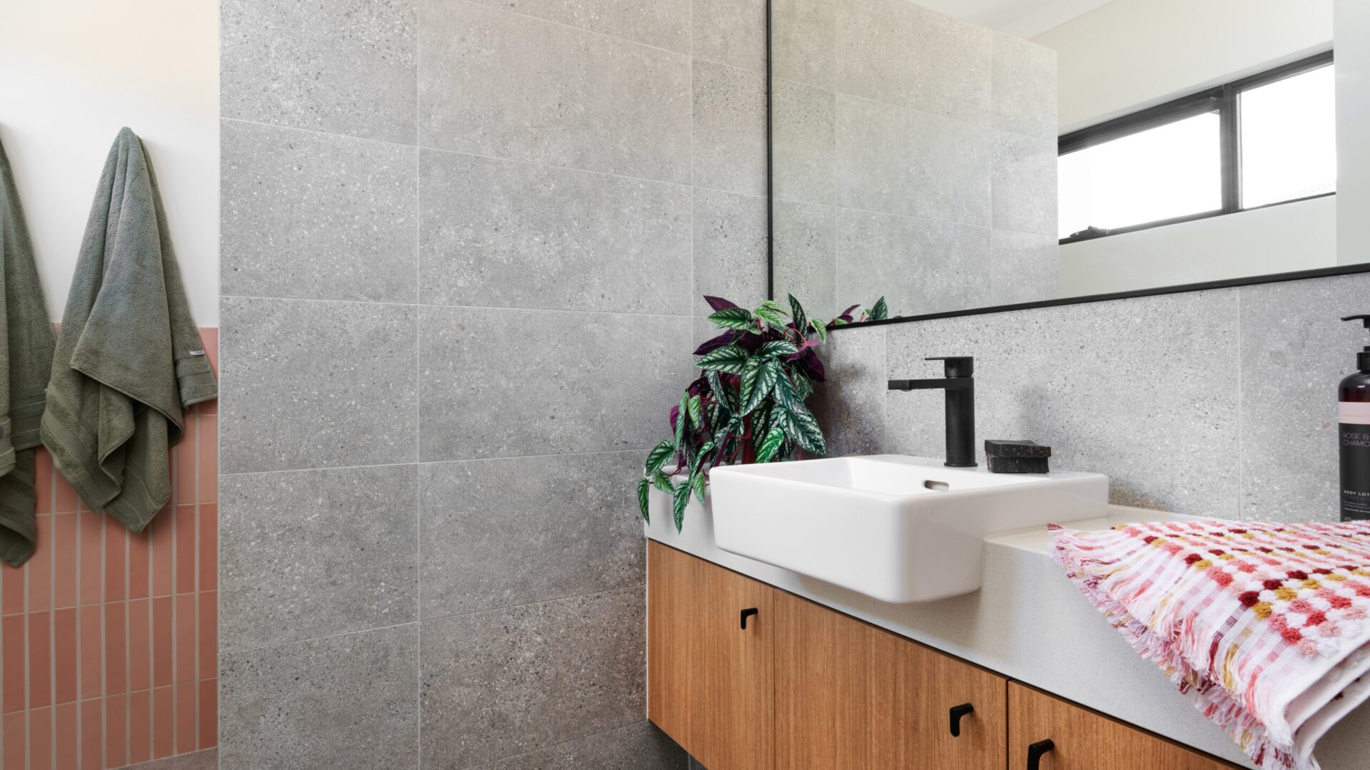 Bathroom with grey tiling, timber vanity and vessel basin