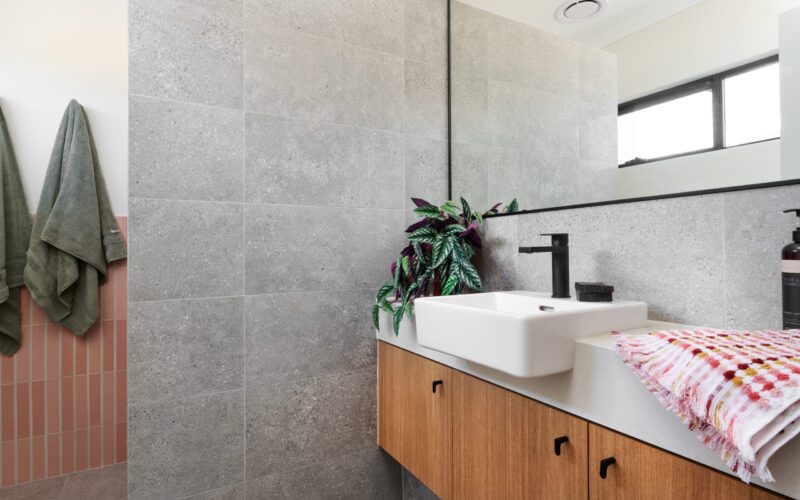 Bathroom with grey tiling, timber vanity and vessel basin