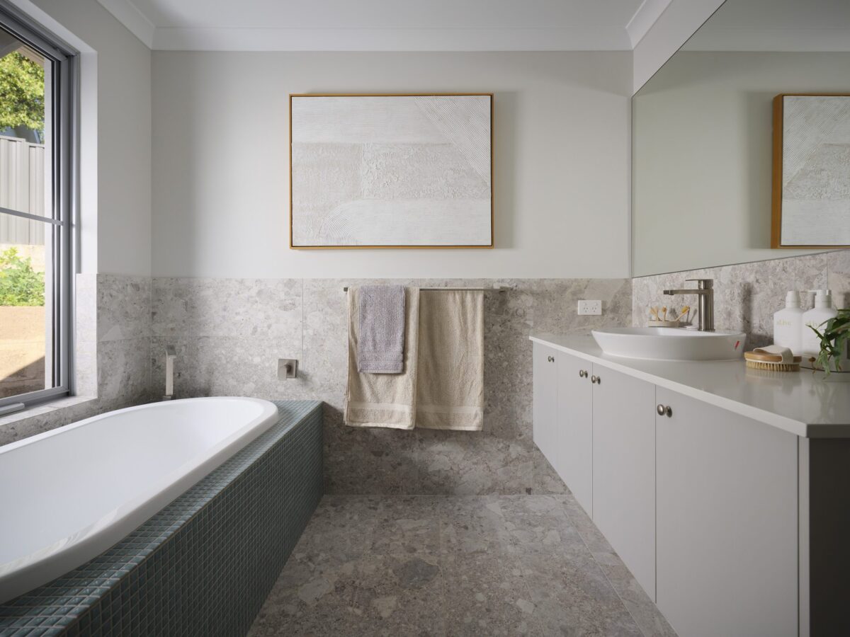 Bathroom with built in bath, stone benchtop and framed artwork