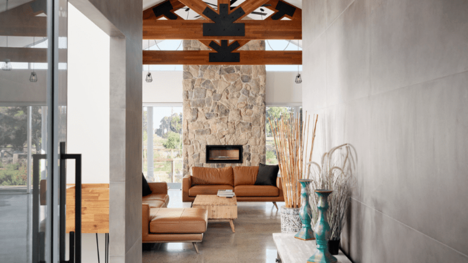 Hallway looking through to a living area with exposed truss and stone fireplace