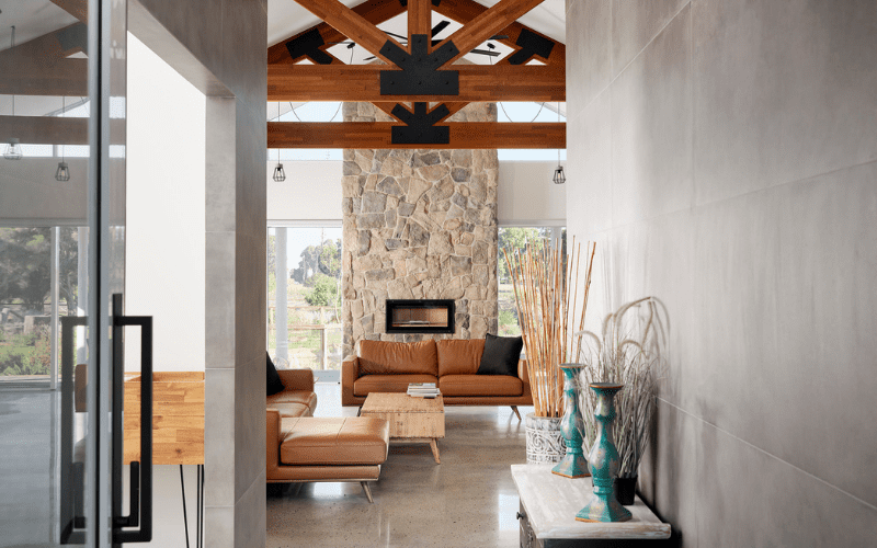 Hallway looking through to a living area with exposed truss and stone fireplace